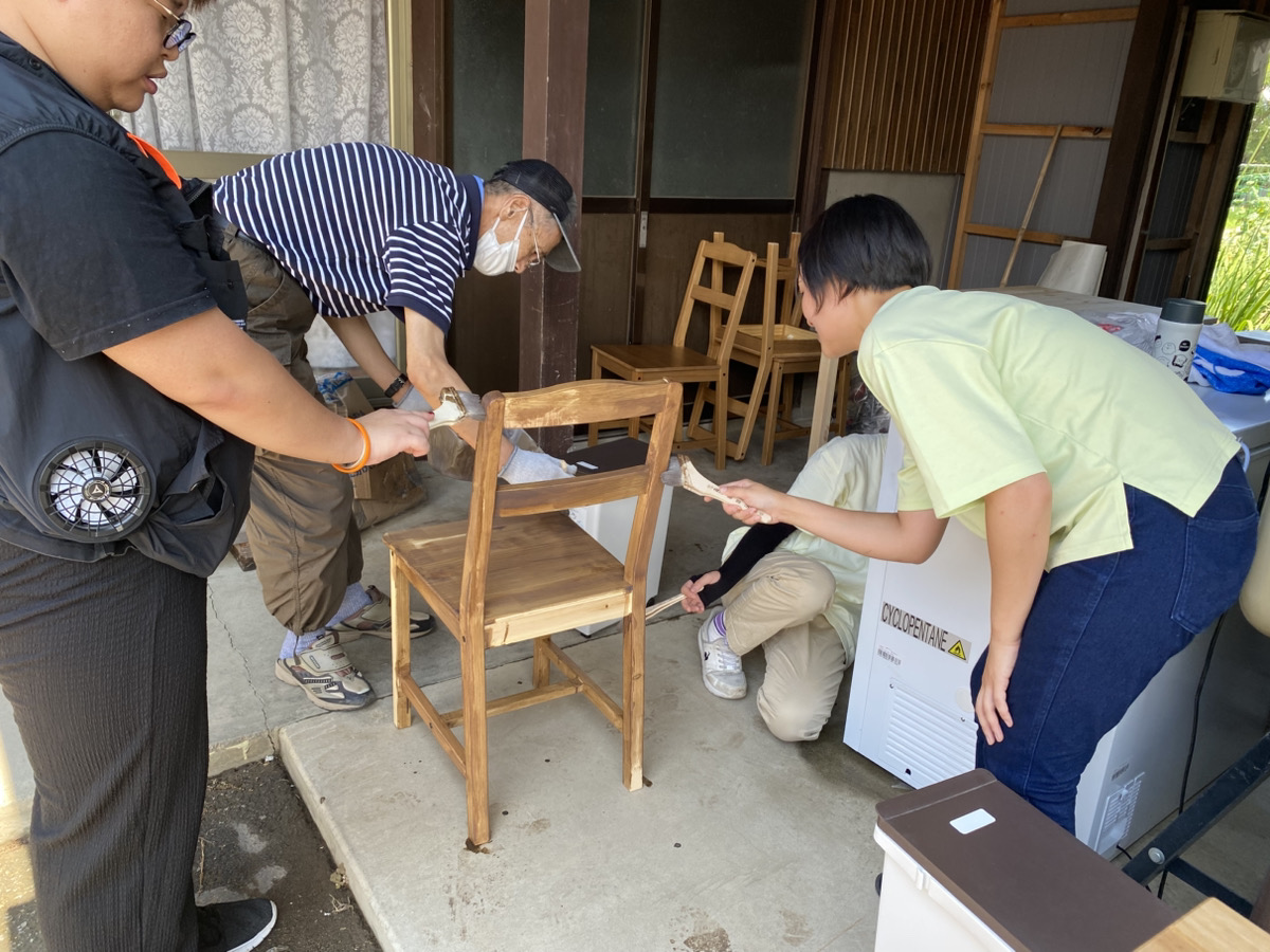 地域食堂で使う木製の椅子を丁寧に塗装する作業風景